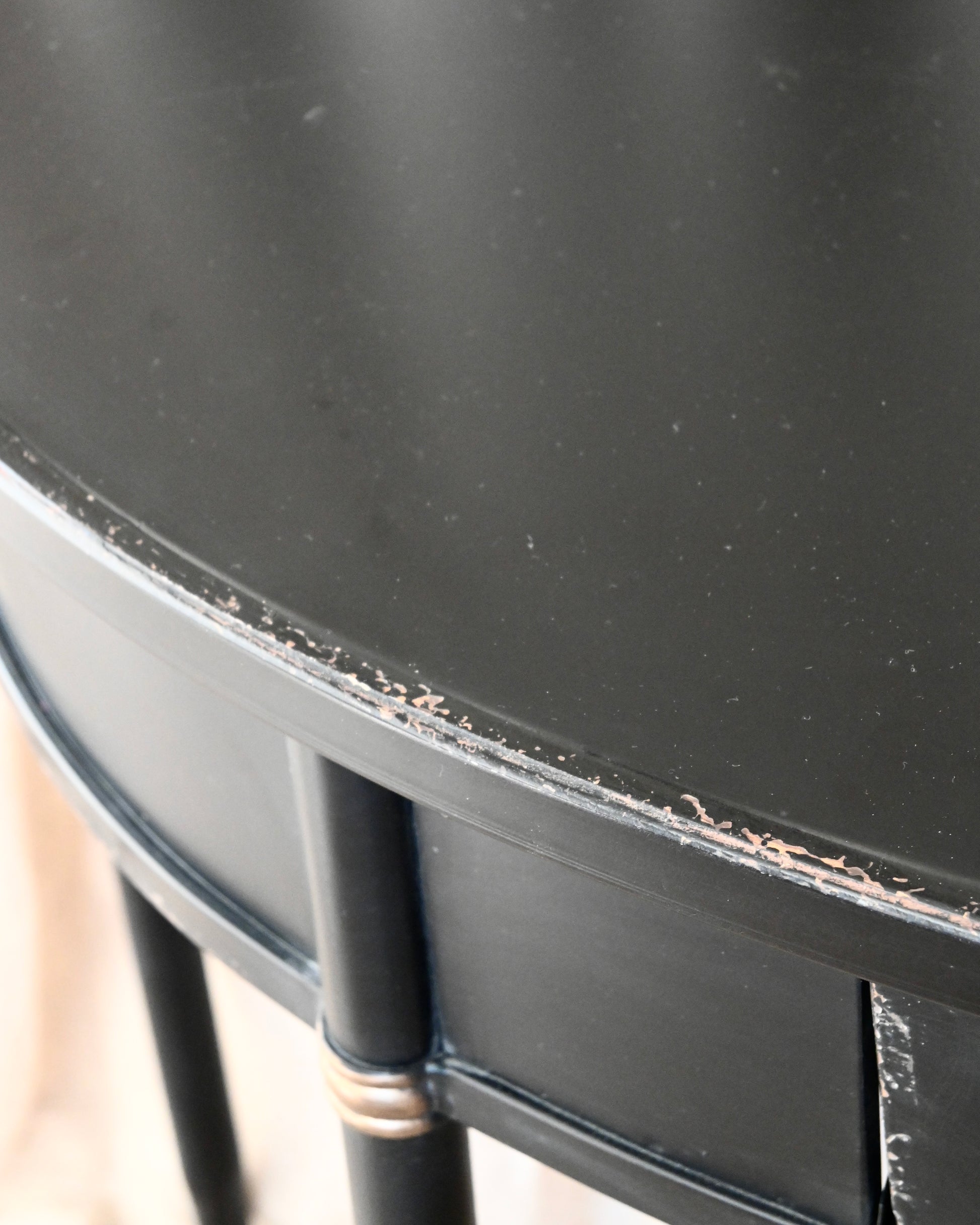 Consola semicircular en chapa negra con acabado envejecido.